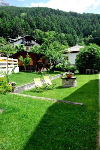a yard with two chairs in the grass at Casa Reit in Bormio