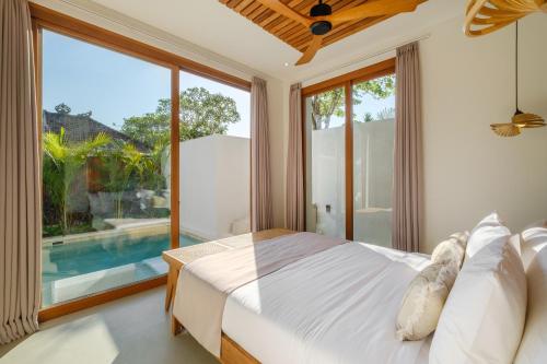 a bedroom with a bed and a large window at Las Hermanas Villa by MAR Bali in Dalung