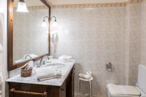 a bathroom with a sink and a toilet and a mirror at Locanda dei Fiori in Pistoia