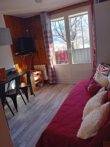 sala de estar con sofá, mesa y puerta en chamois tétras marmotte, en Allos