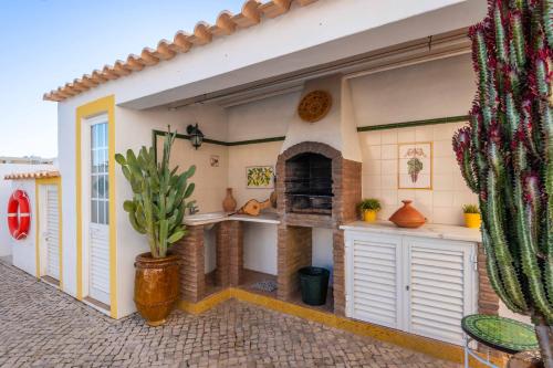 a outdoor kitchen with a pizza oven in a house at Villa Galé Sun - Luxury, 5bed with free wifi, AC, private pool, 5 min from the beach in Guia
