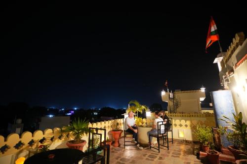 2 persone sedute a un tavolo su un balcone di notte di Rajputana Heritage a Sawai Madhopur
