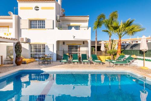 a villa with a swimming pool in front of a house at Villa Galé Sun - Luxury, 5bed with free wifi, AC, private pool, 5 min from the beach in Guia