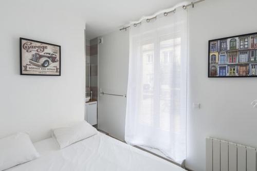 une chambre blanche avec un lit et une fenêtre dans l'établissement Eclipsa - Appartement de charme centre-ville, à Reims