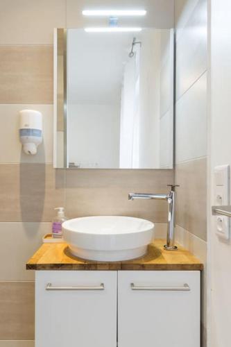 une salle de bain avec un lavabo blanc et un miroir dans l'établissement Eclipsa - Appartement de charme centre-ville, à Reims