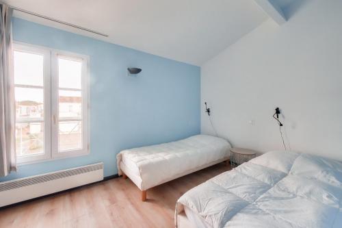 een slaapkamer met 2 bedden en een raam bij Jolie maison en residence - paradis des familles - Re Liberte in La Flotte