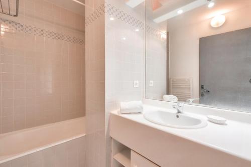 een badkamer met een wastafel, een bad en een spiegel bij Jolie maison en residence - paradis des familles - Re Liberte in La Flotte