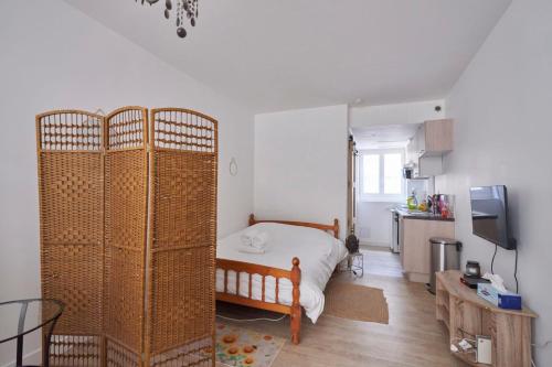 une petite chambre avec un lit et une cuisine dans l'établissement Une nuit à Bord de Garonne - WIFI, à Langon