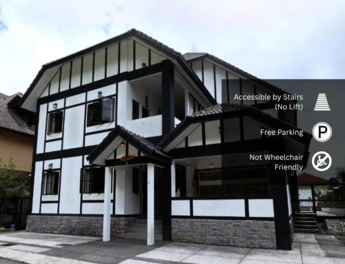 a black and white building with a sign in front of it at PLAY at Arabella Tudor House in Tanah Rata