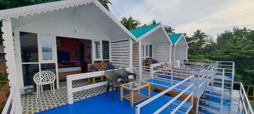 a tiny house on a deck with a table and chairs at Pacific Sunset View Palolem in Palolem