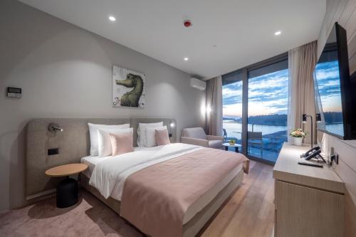 a bedroom with a large bed and a large window at Sea Star Budva in Budva