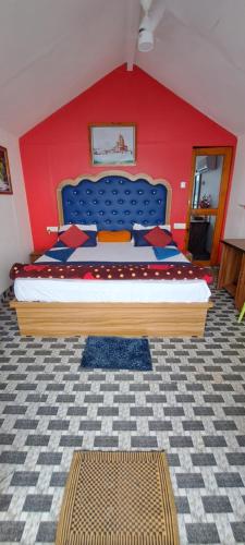 a bedroom with a large bed with a red wall at Pacific Sunset View Palolem in Palolem