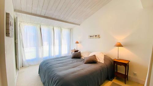 - une chambre avec un lit et une grande fenêtre dans l'établissement Proche plage de la Cible, villa familiale avec annexe, jardin et parking, à Saint-Martin-de-Ré