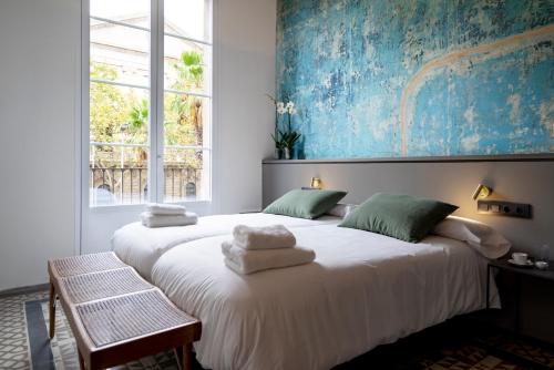 a bedroom with two beds with towels on them at Hostal Porxos Garden in Barcelona