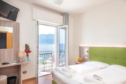 Schlafzimmer mit einem Bett und Meerblick in der Unterkunft Hotel Menapace in Torri del Benaco