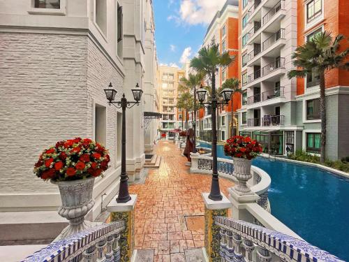 a balcony with two vases filled with flowers and a pool at Espana Vacation Residence Jomtien & Yahaha in Pattaya South