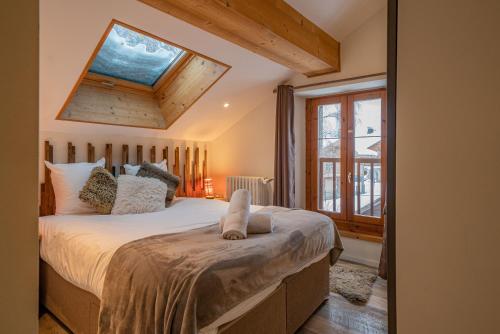1 dormitorio con 1 cama grande y tragaluz en Loft apartment High Rimaye, en Chamonix-Mont-Blanc