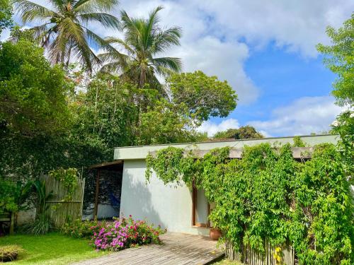 a house with a garden and palm trees at Morada das Marés in Arraial d'Ajuda