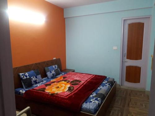 - une chambre avec un lit et une couverture rouge dans l'établissement Hateshwari Guest House, à Shimla