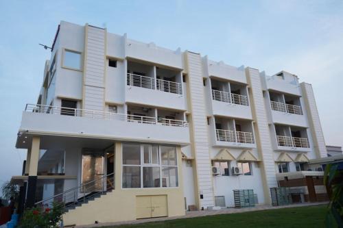 un gran edificio blanco con balcones. en Swet Palash Resort, en Purulia