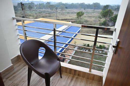 a black chair sitting on a balcony with a view at Swet Palash Resort in Purulia
