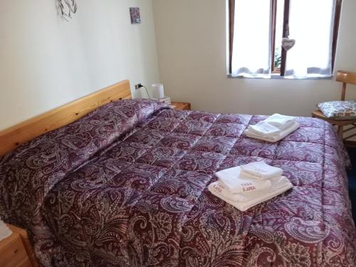 ein Bett mit zwei Handtüchern darüber in der Unterkunft CASA ILARIA in Faidello