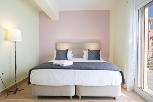 a bedroom with a large bed in a room with a window at Sea n' Smile in Apolpaina