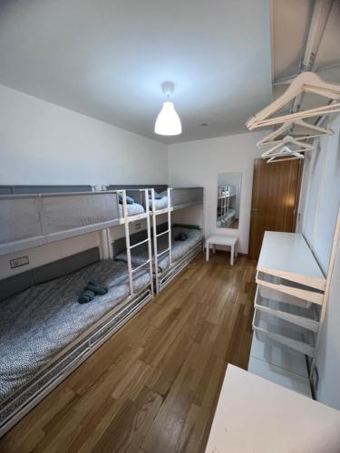 um quarto com 2 beliches e uma mesa em Apartamento en Sabiñánigo para grupos con amplia y soleada terraza em Huesca