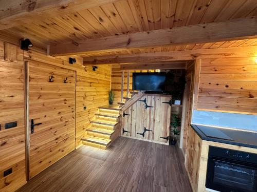 a room with wooden walls and a door with a television at Zaovinska idila in Bjeluša