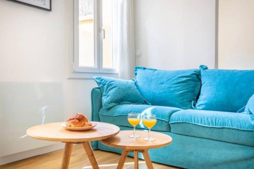 - un salon avec deux tables et un canapé bleu dans l'établissement 14 THU Happynest, charmant appartement coeur de Marseille, à Marseille