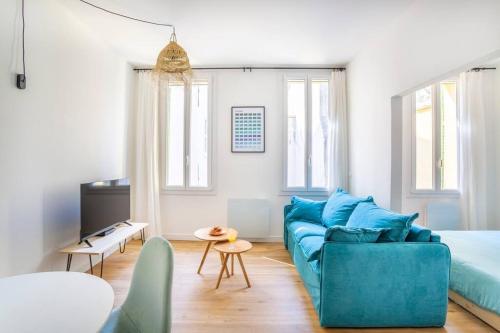 - un salon avec un canapé bleu et un lit dans l'établissement 14 THU Happynest, charmant appartement coeur de Marseille, à Marseille