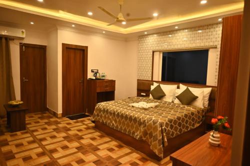 a hotel room with a bed and a television at Swet Palash Resort in Purulia