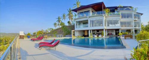 a large house with a swimming pool in front of it at Yupa Penthouse in Amphoe Koksamui