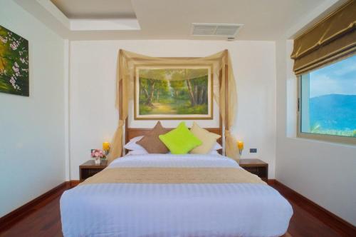 een slaapkamer met een groot bed en een raam bij Yupa Penthouse in Nathon Bay