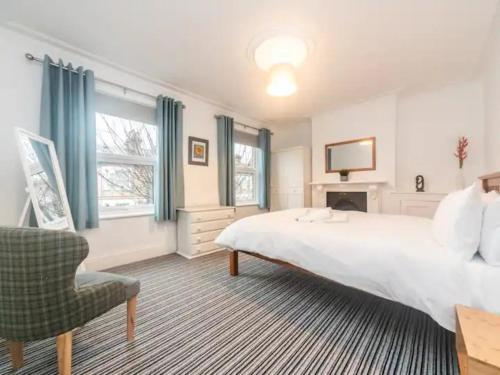 una camera con un grande letto bianco e una sedia di Pass the Keys Characterful Victorian Home Near Central London a Londra