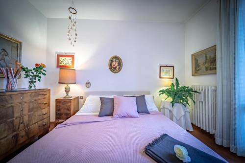 1 dormitorio con 1 cama grande con sábanas moradas en Borgo Spedaletto 5 - Dolcevita Holiday, en Grassina