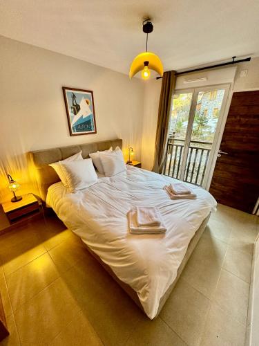 une chambre avec un grand lit avec deux serviettes dessus dans l'établissement AURON 2P NEUF - Le Mont d'Auron, à Auron