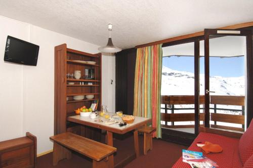 a room with a table with a view of a mountain at Résidence Odalys Tourotel in Val Thorens