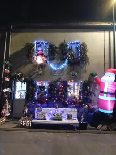 a house decorated with christmas lights and a snowman at La Roulotte De Lola - Chambre d'hôtes in La Celle
