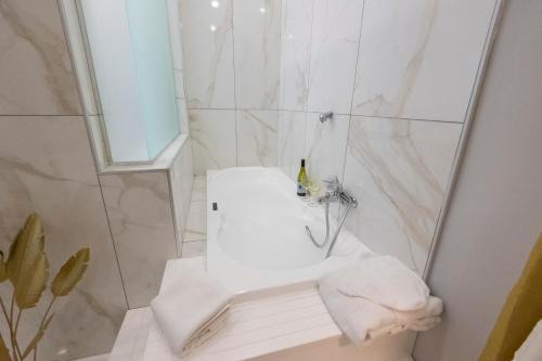 a white bathroom with a shower with a sink at Enchanting Suites Salerno in Salerno