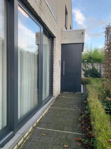 a black door on a house with a walkway at Guestsuite The Nest in Wielsbeke
