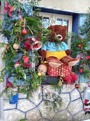 a stuffed teddy bear sitting on a window sill at La Roulotte De Lola - Chambre d'hôtes in La Celle