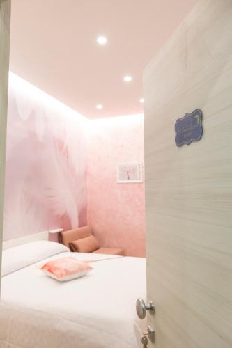 a room with a bed and a door with a chair at Enchanting Suites Salerno in Salerno