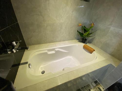 a white bath tub in a bathroom with a plant at Villa Mabuk in Legian