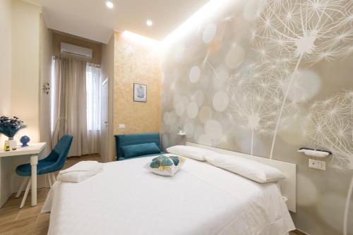 a bedroom with a white bed and a blue chair at Enchanting Suites Salerno in Salerno