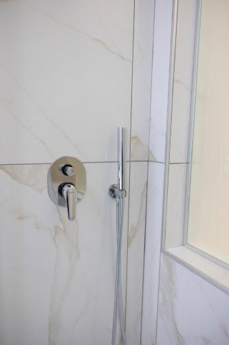a shower with a faucet in a bathroom at Enchanting Suites Salerno in Salerno