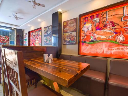 a wooden table in a restaurant with posters on the wall at Hotel Dosa plaza in Udaipur