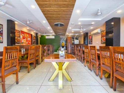a restaurant with a wooden table and wooden chairs at Hotel Dosa plaza in Udaipur