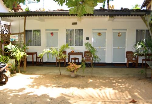 une maison avec des chaises et des tables dans une cour dans l'établissement Kosi Giggles Resort, à Weligama