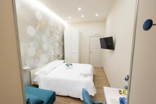 a bedroom with a white bed and a blue chair at Enchanting Suites Salerno in Salerno